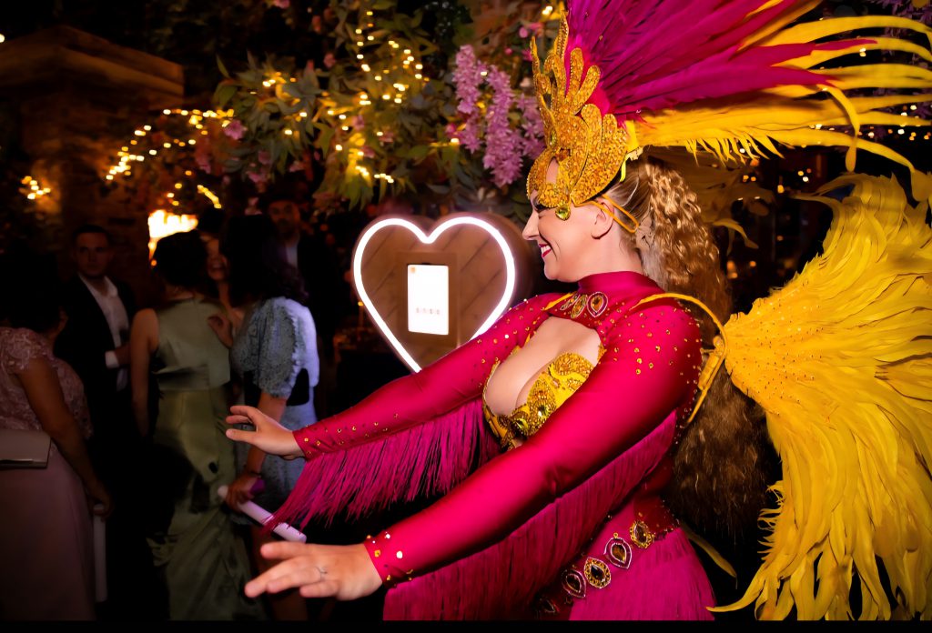 Selfie Mirror Photobooth Liverpool. Photo of a samba dancer with our heart selfie in the background. Selfie Mirror hire Liverpool and surrounding areas